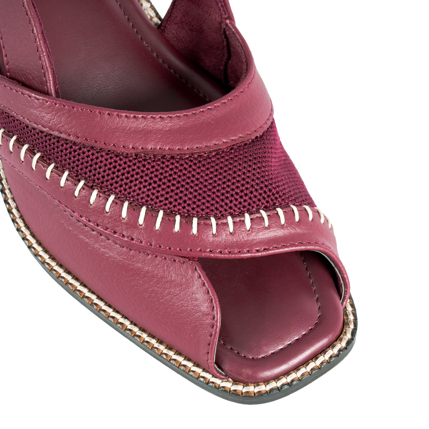 Close-up of a Burgundy sandal with open toe and gold stitching on a white background