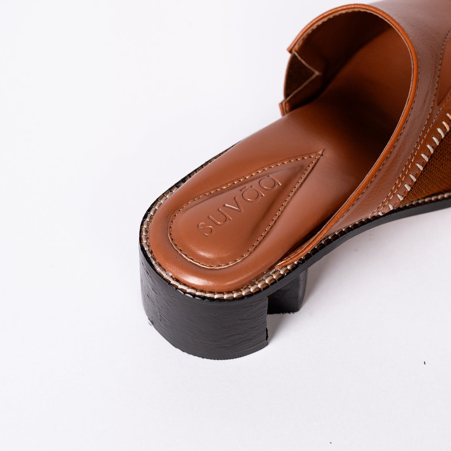 Brown sandal with 'SUICOKE' branding on a white background