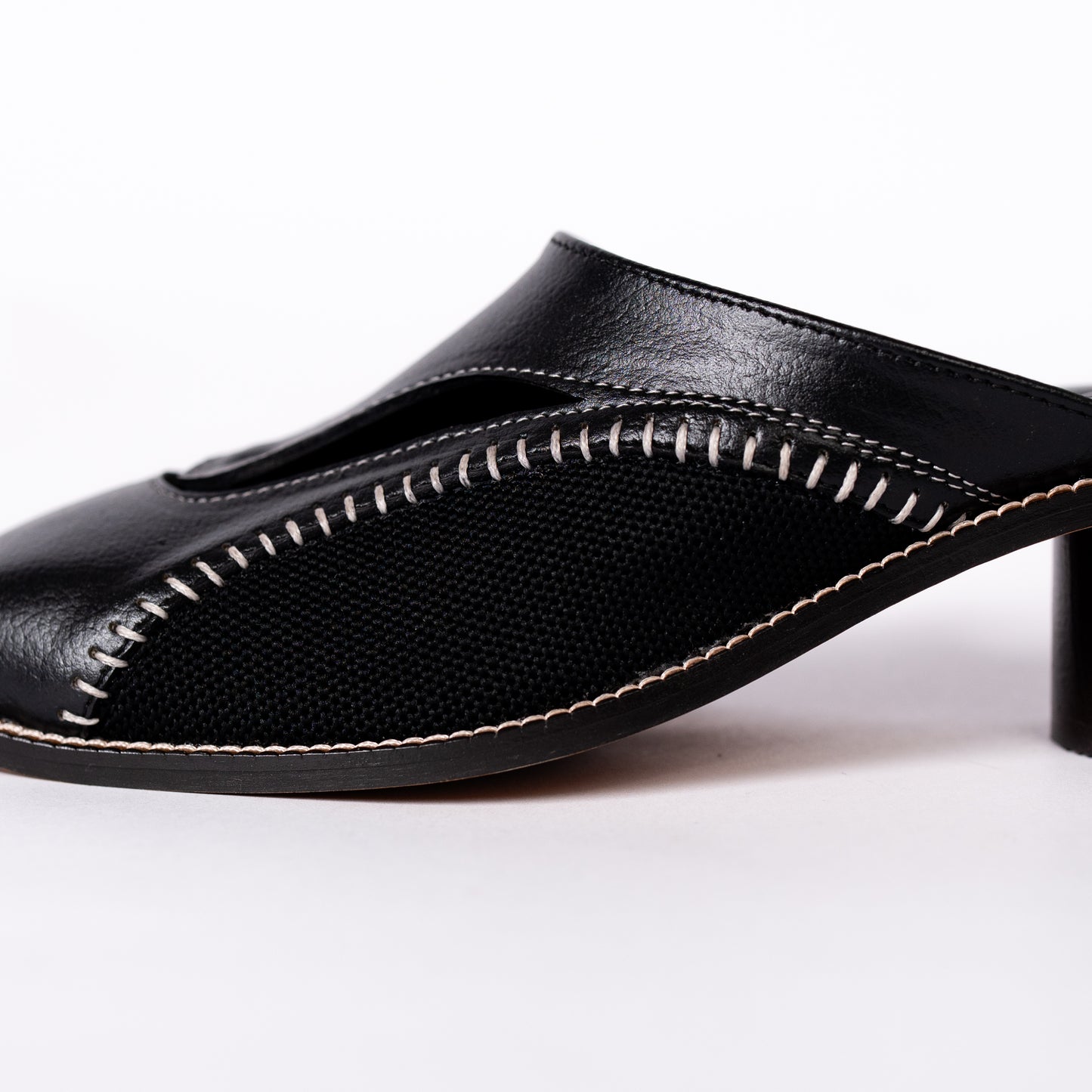 Black leather sandal with open toe design on a white background