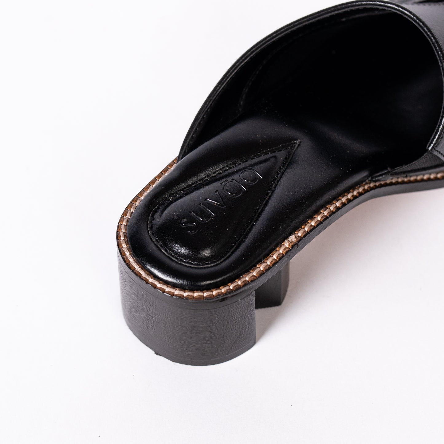Black mules with a brand logo on a white background