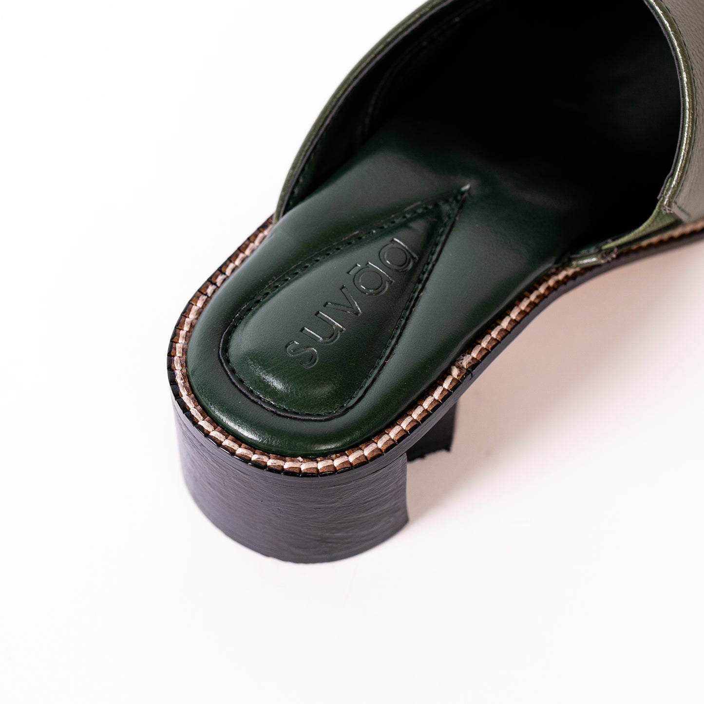 Olive shoe with 'Suvāa' branding on a white background